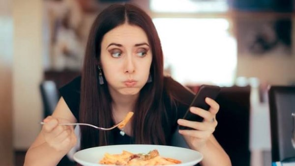ماذا يحدث لجسمك وأنت تمسك الهاتف أثناء الأكل؟ دراسات تكشف مفاجآت