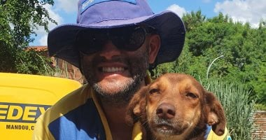 ساعي بريد برازيلي يذيب القلوب بصداقته ولعبه مع الكلاب